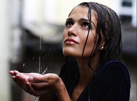 A woman catching a raindrop